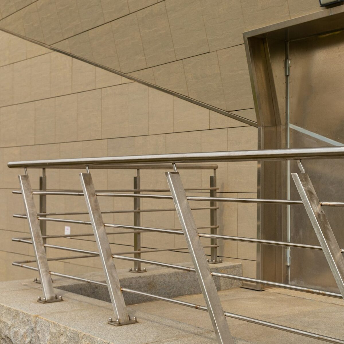 Futuristic design with gray cement walls, metal door and steel fence