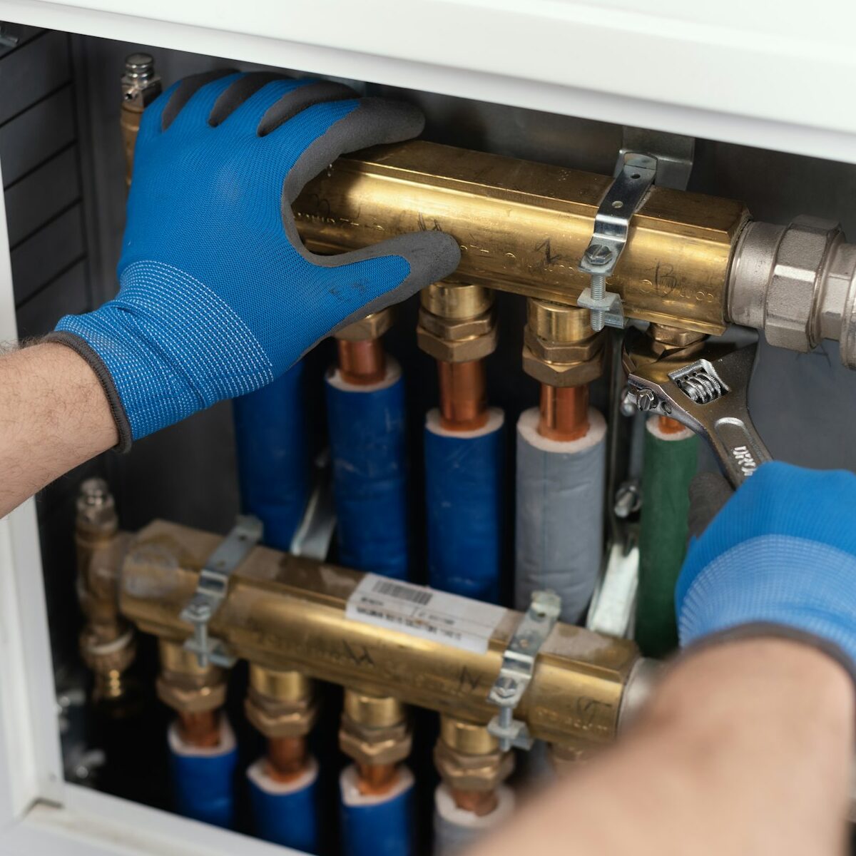 Professional plumber installing plumbing manifolds